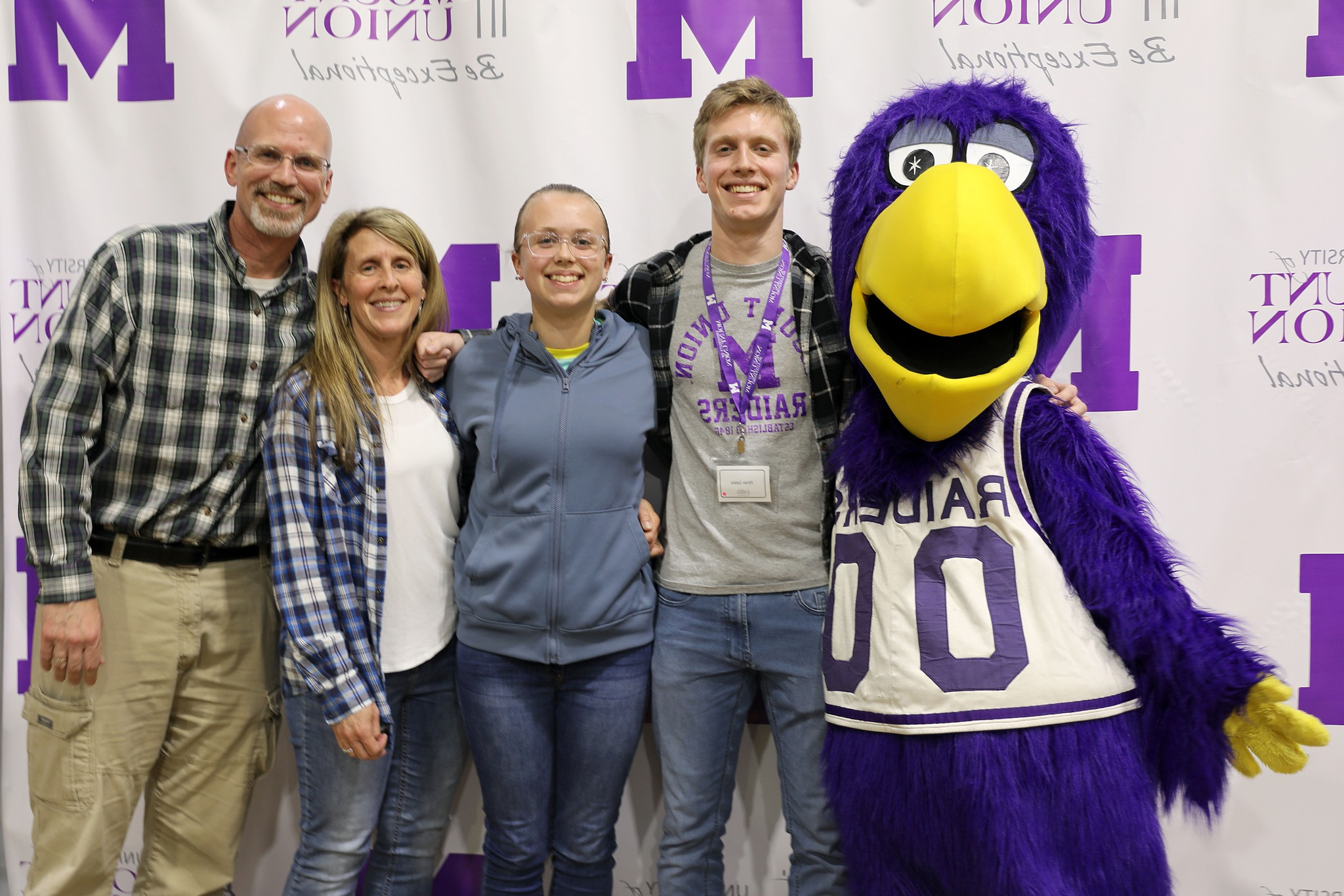 Purple Raider family posing with Mount 联盟 mascot, MUcaw.